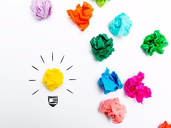scrunched up pieces of coloured paper, one representing a yellow lightbulb